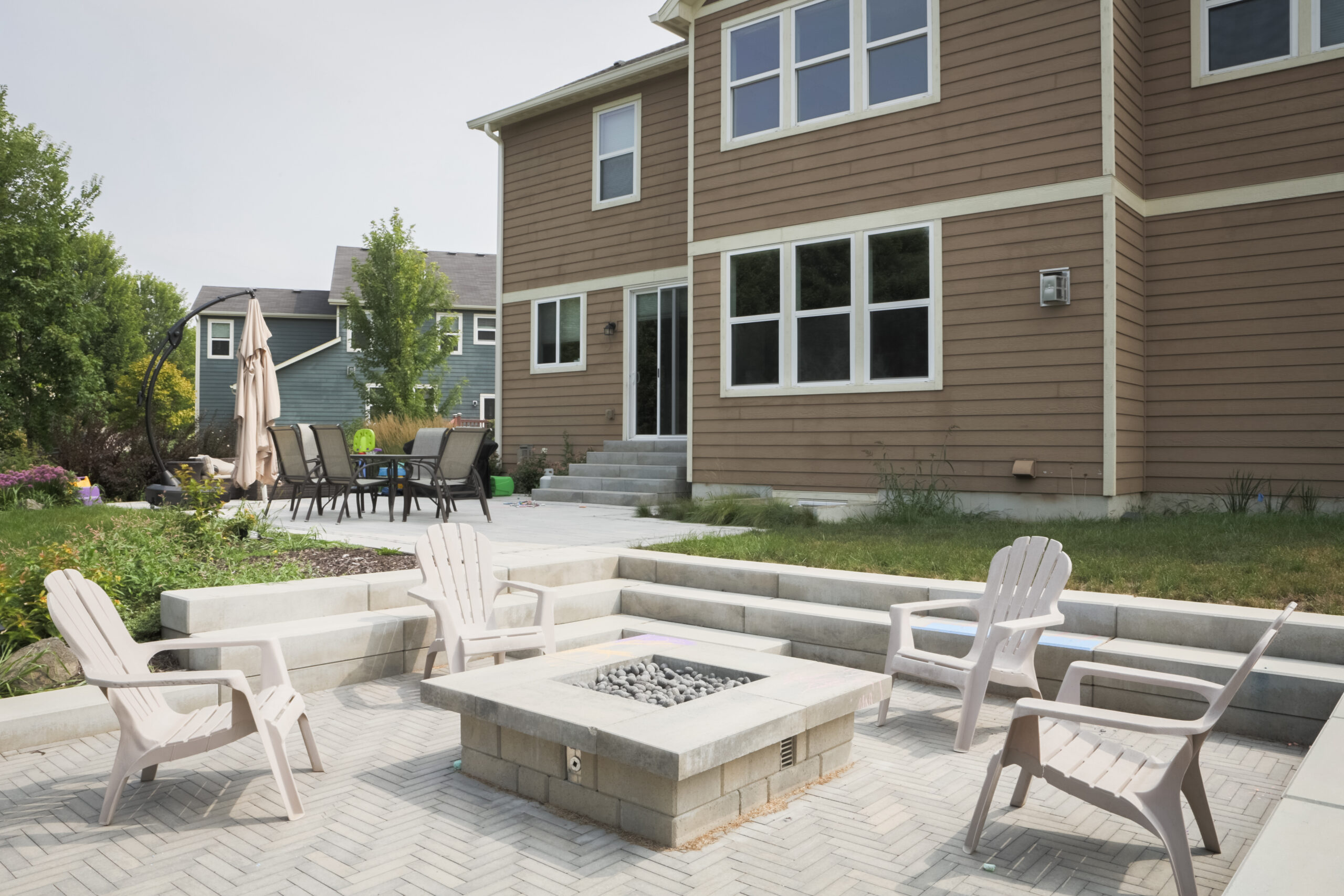 Sunken gas fire pit patio surrounded by step units for tiered seating
